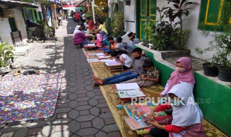 Anak-anak siswa SD belajar bersama jalan kampung di Bintaran Kidul, Yogyakarta, Rabu (29/7). Layanan Internet Masyarakat (LIMas) memberikan kases internet gratis untuk anak-anak untuk mempermudah kegiatan belajar secara daring.