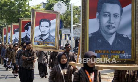 Sejumlah peserta berjalan membawa foto pahlawan revolusi saat Kirab Merah Putih di Kabupaten Batang, Jawa Tengah, Ahad (1/10/2023). Kirab merah putih dalam rangka memperingati Hari Kesaktian Pancasila itu, diikuti sekitar 4.500 orang yang mengarak foto pahlawan revolusi dan bendera merah putih sepanjang sekitar satu kilometer yang bertujuan untuk mengenang jasa pahlawan revolusi dan meningkatkan ideologi bangsa kepada seluruh lapisan masyarakat. 