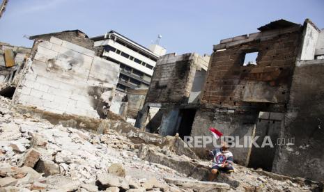 Seorang anak bermain sambil memegang bendera Merah Putih di lokasi bekas kebakaran Pasar Gembrong di Cipinang Besar Utara, Jakarta, Jumat (1/7/2022). Pemprov DKI Jakarta telah memulai proses revitalisasi permukiman korban kebakaran Pasar Gembrong di RW 001 yang akan diberi nama Kampung Gembira Gembrong dengan target rampung pada September 2022 serta menelan biaya Rp7,8 miliar. 