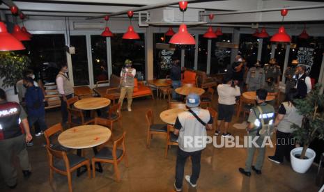 Sejumlah anggota Satpol PP Kota Bogor melakukan sidak pembatasan jam operasional kafe dan resto di jalan Pajajaran, Kota Bogor, Jawa Barat, Senin (31/8/2020). Dalam sidak tersebut, Satpol PP Kota Bogor memberikan sanksi berupa denda mulai Rp.500 ribu hingga Rp.5 juta rupiah bagi rumah makan, restoran maupun kafe yang melanggar pembatasan jam operasional melebihi batas waktu pukul 18.00 WIB di masa Pembatasan Sosial Berskala Mikro dan Komunitas (PSBMK) dalam upaya memutus mata rantai penyebaran COVID-19 di wilayah zona merah Kota Bogor.