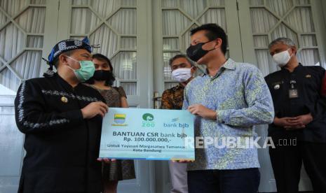 Wali Kota Bandung Oded M Danial (kiri) secara simbolis menyerahkan bantuan CSR Bank BJB kepada Ketua Yayasan Bandung Zoological Garden John Sumampau, di Pendopo, Kota Bandung, Kamis (14/5). Oded berharap bantuan sebesar Rp 100 juta tersebut dapat membantu pemeliharaan satwa di Kebun Binatang Bandung di tengah masa pandemi Covid-19