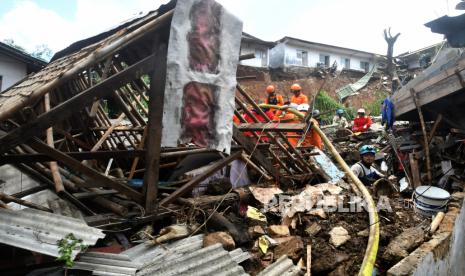 Sejumlah petugas Basarnas dan BPBD Kota Bogor melakukan pencarian korban tanah longsor di Gang Barjo, Kampung Kebon Jahe, Kelurahan Kebon Kelapa, Kota Bogor, Jawa Barat, Kamis (13/10/2022). Pemerintah Kota Bogor mencatat sebanyak delapan warga di kampung tersebut tertimbun tanah longsor saat hujan deras pada Rabu (12/10/2022) sore dengan empat warga selamat dievakuasi, satu warga meninggal dunia dan tiga warga lainnya masih dalam proses pencarian. 