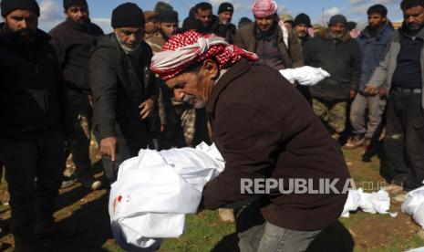  Para pelayat mengubur anggota keluarga yang meninggal dalam gempa dahsyat yang mengguncang Suriah dan Turki di sebuah pemakaman di kota Jinderis, provinsi Aleppo, Suriah, Selasa (7/2/2023). Seorang bayi perempuan ditemukan terkubur di bawah puing-puing dengan tali pusarnya masih utuh terkait dengan ibunya, Afraa Abu Hadiya, yang ditemukan tewas, menurut kerabat dan dokter. Bayi itu adalah satu-satunya anggota keluarganya yang selamat dari bangunan yang runtuh pada Senin di Jinderis, di sebelah perbatasan Turki, Ramadan Sleiman, seorang kerabat, mengatakan kepada The Associated Press.