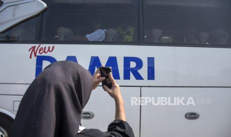 Warga mengambil gambar armada bus Damri.