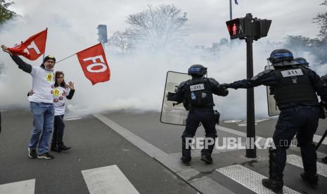  Para pengunjuk rasa mengibarkan bendera serikat buruh Force Ouvriere (FO) di samping polisi anti huru hara selama unjuk rasa menentang reformasi pensiun pemerintah di Paris, Prancis, Selasa (28/3/2023). Prancis menghadapi pemogokan nasional yang sedang berlangsung menentang reformasi pensiun pemerintah setelah perdana menteri Prancis mengumumkan pada 16 Maret 2023 penggunaan Pasal 49 paragraf 3 (49.3) Konstitusi Prancis agar teks undang-undang reformasi pensiun yang kontroversial - menaikkan usia pensiun dari 62 menjadi 64 - diadopsi secara definitif tanpa pemungutan suara.