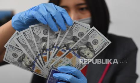 Petugas menata mata uang dolar AS di salah satu gerai penukaran uang asing di Jakarta, Kamis (19/3/2020). 