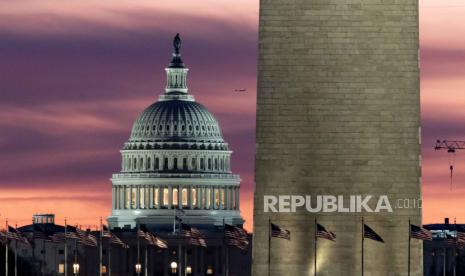 Gedung Capitol Amerika Serikat terlihat di belakang dasar Monumen Washington sekitar fajar di Washington, DC, AS, (3/1/2024).