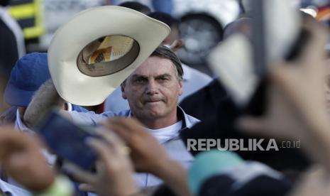 Presiden Brasil Jair Bolsonaro melambai kepada anggota komunitas agribisnis yang telah berkumpul untuk menunjukkan dukungan mereka, di Brasilia, Brasil, Sabtu, 15 Mei 2021.