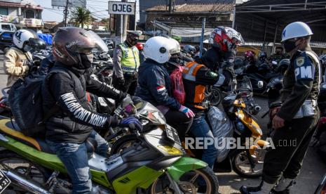 Petugas gabungan melakukan penyekatan kendaraan dengan plat nomor dari luar Bandung di posko penyekatan larangan mudik di gerbang Tol Padalarang, Kabupaten Bandung Barat, Senin (10/5). Pada hari kelima penerapan larangan mudik Lebaran 2021, petugas gabungan di posko penyekatan larangan mudik Padalarang telah memutarbalikan sedikitnya 30 kendaraan berplat luar kota karena tidak memiliki surat kesehatan serta ijin perjalanan. Foto: Republika/Abdan Syakura