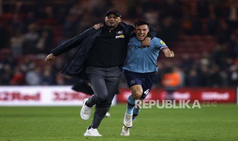 Manajer Burnley Vincent Kompany, kiri, dan Jack Cork merayakan promosi ke Liga Premier setelah pertandingan sepak bola Kejuaraan Inggris melawan Middlesbrough, Jumat, 7 April 2023, di Stadion Riverside, di Middlesbrough, Inggris.