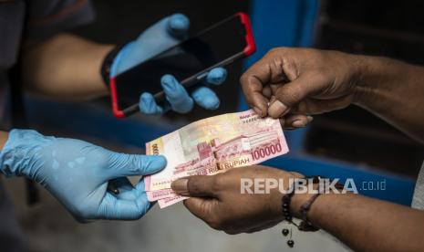 Petugas PT Pos Indonesia menyalurkan Bantuan Sosial Tunai (BST) kepada warga. Setiap KK akan menerima BST sebesar Rp 300 ribu.