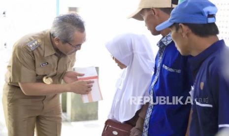 Bupati Bantul Abdul Halim Muslih melakukan penyerahan secara simbolis bantuan perbaikan rumah tidak layak huni, Senin (26/6/2023).