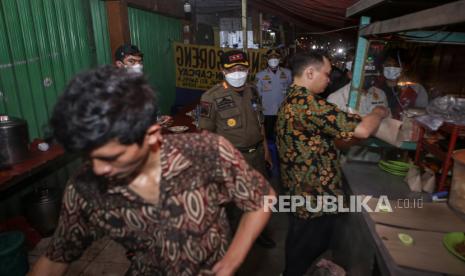 Petugas Satpol PP meminta pedagang untuk menutup warungnya saat sidak penerapan Pemberlakuan Pembatasan Kegiatan Masyarakat (PPKM) Darurat di Kota Tangerang, Banten, Minggu (4/7/2021). Petugas gabungan TNI, Polri dan Pemerintah Kota Tangerang melakukan sidak ke berbagai titik di wilayah Kota Tangerang untuk memastikan penerapan PPKM Darurat di Kota Tangerang berjalan sesuai aturan guna menekan angka penyebaran COVID-19. 