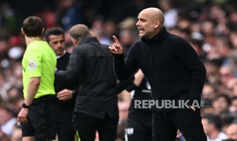 Pelatih Manchester City Pep Guardiola memberi instruksi dalam pertandingan sepak bola Liga Primer Inggris antara Man City vs Fulham di Craven Cottage, London, Inggris, Ahad (30/4/2023). Di laga itu, Man City menang 2-1.