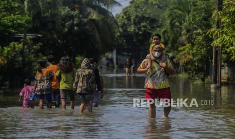 Pemerintah Kota Tangerang Selatan (Tangsel) menyampaikan ada empat kecamatan dari tujuh kecamatan di Tangsel yang menjadi fokus penanganan banjir ke depan. Foto. Seorang warga menggendong anaknya saat terjadi banjir di Perumahan Nerada Estate, Ciputat, Tangerang Selatan, Sabtu (12/6). Banjir diakibatkan aliran Kali Baung yang tertutup longsoran turap itu membuat komplek Perumahan Nerada Estate terendam banjir hingga ketinggian 50 sentimeter. 