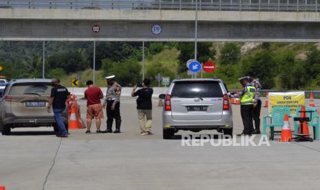 Petugas Kepolisian Polda Lampung memeriksa kendaraan yang keluar jalan tol melalui gerbang tol Bakauheni Selatan di Lampung Selatan, Lampung, Sabtu (23/5/2020). Pemeriksaan tersebut sebagai upaya penyekatan pemudik yang hendak keluar atau masuk Provinsi Lampung untuk memutus rantai penyebaran COVID-19