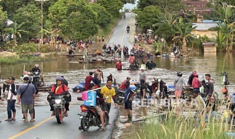 Sejumlah warga dan kendaraan memadati ruas jalan Sintang-Putussibau yang putus akibat terendam banjir di Kabupaten Sintang, Kalimantan Barat, Sabtu (13/11/2021). BPBD Kabupaten Sintang menyatakan banjir masih merendam beberapa kecamatan di daerah setempat, meski demikian banjir telah surut 10 hingga 15 sentimeter pada Jumat (12/11/2021) kemarin. 