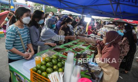 Pedagang melayani pembeli di pasar Ramadhan di kawasan Jalan AIS Nasution, Palangkaraya, Kalimantan Tengah, Ahad (3/4/2022). Setelah dua tahun meniadakan pasar Ramadhan akibat pandemi COVID-19, Pemkot Palangkaraya kembali menggelar pasar tersebut pada bulan Ramadhan 1443 Hijriah guna mempermudah warga setempat mendapatkan aneka menu makanan untuk berbuka puasa. 