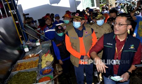 Menteri Sosial Juliari P Batubara (kanan) dan Kepala Badan Nasional Penanggulangan Bencana (BNPB) Doni Monardo (ketiga kanan) didampingi Gubernur Sulawesi Selatan Nurdin Abdullah (kedua kanan) dan Bupati Luwu Utara Indah Putri Indriani (kedua kiri) berkunjung ke dapur umum posko pengungsian di Masamba, Kabupaten Luwu Utara, Sulawesi Selatan, Jumat (17/7/2020). Kunjungan tersebut untuk meninjau dan memberikan santunan kepada korban banjir bandang. ANTARA FOTO/Abriawan Abhe/wsj.