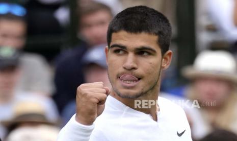 Petenis Spanyol Carlos Alcaraz merayakan kemenangannya pada set ketiga melawan Jannik Sinner dari Italia dalam pertandingan tunggal putra putaran keempat pada hari ketujuh kejuaraan tenis Wimbledon di London, Minggu, 3 Juli 2022.