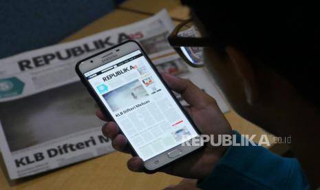 Warga membaca epaper koran Republika melalui perangkat telepon genggam di Jakarta, Jumat (29/12) lalu. Republika sebagai salah satu anak perusahaan MahakaX (IDX: ABBA) bertransformasi penuh menjadi media massa dengan format digital per 1 Januari 2023. 