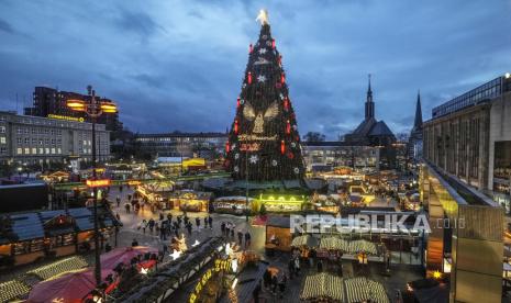 Pohon Natal terbesar di Jerman diterangi hanya untuk beberapa pengunjung di pasar Natal di Dortmund, Jerman, Rabu, 1 Desember 2021. Menteri Kesehatan Jerman mengesampingkan lockdown sebelum Natal.