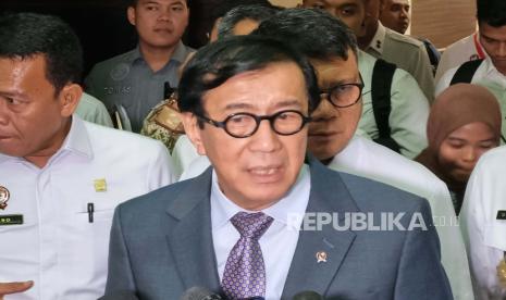 Menteri Hukum dan HAM (Menkumham) Yasonna H Laoly menghampiri kerumunan wartawan, sementara Wamenkumham Edward Omar Sharif Hiariej atau Eddy kabur melalui pintu di belakang Ruang Rapat Komisi III DPR, Kompleks Parlemen, Jakarta, Selasa (21/11/2023). 