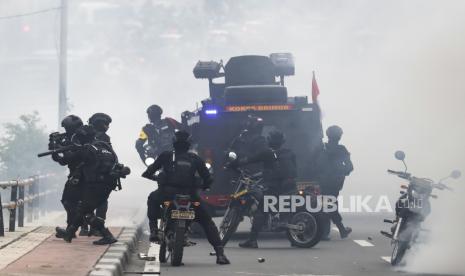 Aparat polisi menggunakan gas air mata untuk membubarkan pengunjuk rasa selama demonstrasi di luar gedung parlemen di Jakarta, Indonesia, 11 April 2022. 