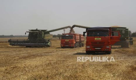 Petani memanen dengan kombinasi mereka di ladang gandum dekat desa Tbilisskaya, Rusia, 21 Juli 2021.