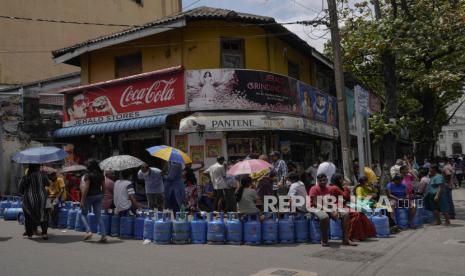 Orang-orang menunggu dalam antrian mengharapkan untuk membeli gas memasak di dekat pusat distribusi di Kolombo, Sri Lanka, Selasa, 12 Juli 2022. Menghadapi kekurangan makanan, bahan bakar dan obat-obatan, pengunjuk rasa pada hari Sabtu menyerbu rumah Presiden Gotabaya Rajapaksa yang diperangi, kantornya di tepi pantai dan kediaman resmi perdana menterinya di hari paling dramatis dari krisis tiga bulan.