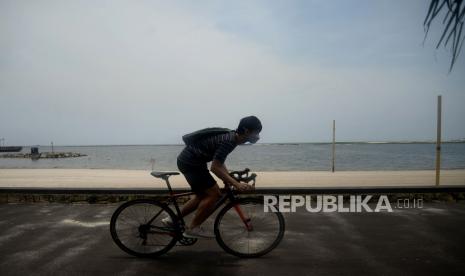 Pengunjung bersepeda di sekitar Pantai Ancol, Jakarta, Senin (12/10). Setelah sempat ditutup sejak 14 September 2020 karena penerapan PSBB di Ibukota, kini kawasan wisata Ancol kembali dibuka seiring dicabutnya status PSBB Jakarta menjadi PSBB transisi.Prayogi/Republika.