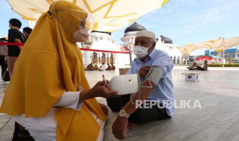 Petugas kesehatan memeriksa tensi darah warga berusia lanjut sebelum mendapatkan vaksin COVID-19 pada vaksinasi merdeka di halaman masjid raya Baiturrahman, Banda Aceh, Aceh, Senin (6/9/2021). Vaksinasi merdeka yang digelar secara serentak pada 6-7 September 2021 di seluruh Indonesia merupakan program sinergi staf khusus Presiden bersama Kapolri dan  Panglima TNI untuk membantu pemerintah memutuskan mata rantai penyebaran serta penularan COVID-19. 