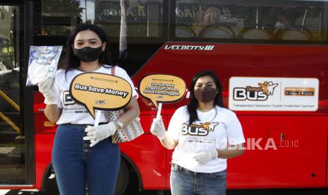 Relawan melakukan sosialisasi Gerakan Kembali ke Angkutan Umum kepada pengguna jalan, di Jalan Slamet Riyadi Solo, Jawa Tengah, Ahad (12/12/2021). Gerakan tersebut merupakan bagian dari program pengembangan angkutan massal berbasis jalan di kawasan perkotaan oleh Kemenhub dengan skema pembelian layanan buy the service (BTS) untuk mengajak masyarakat kembali menggunakan transportasi umum dalam aktivitasnya.