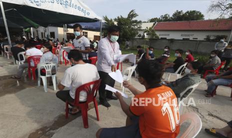  Anggota staf membagikan formulir kepada penduduk desa sebelum dosis kedua mereka di lokasi vaksin COVID-19 Sinopharm, di luar Phnom Penh, Kamboja, Rabu, 28 April 2021.