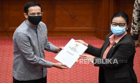 Menteri Pendidikan dan Kebudayaan Nadiem Makarim (kiri) menerima laporan Panitia Kerja (Panja) Pembelajaran Jarak Jauh dari Wakil Ketua Komisi X DPR Agustina Wilujeng Pramestuti (kanan) saat rapat kerja di Kompleks Parlemen Senayan, Jakarta, Kamis (27/8/2020). Rapat kerja tersebut  membahas tentang laporan keuangan Kementerian Pendidikan dan Kebudayaan Tahun Anggaran 2019, proses hibah hak paten merdeka belajar serta kebijakan sekolah yang berada dalam zona hijau COVID-19. A