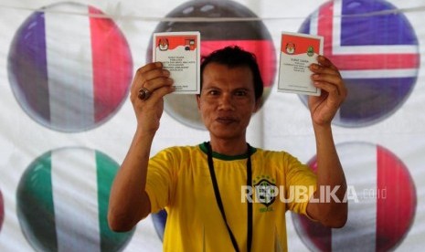 Warga menunjukan surat suara saat Pilkada serentak 2018 di TPS 19, Sempur, Bogor, Jawa Barat, Rabu (27/6).