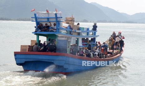 Sejumlah pemudik menumpang kapal kayu tujuan wilayah terluar Pulau Aceh meninggalkan pelabuhan Ulee Lheue, Banda Aceh, Aceh, Ahad (10/3/2024). Pemudik menggunkan angkutan penyeberangan kapal kayu untuk kembali ke daerahnya sehubungan dengan perayaan tradisi Meugang dalam menyambut bulan Ramadhan 1445 Hijriah. 