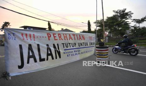 Pengendara sepeda bermotor melintasi spanduk penutupan jalan di kawasan Pondok Pinang, Jakarta, Rabu (1/4/2020). Penutupan jalan di kawasan Pondok Pinang, Kecamatan Kebayoran Lama tersebut merupakan inisiatif warga untuk mencegah penyebaran virus corona (COVID-19) di sekitar tempat tinggal mereka