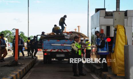 Petugas membersihkan sisa-sisa barang yang tercecer di lokasi Tempat Kejadian Perkara (TKP) kecelakaan beruntun di Gerbang Tol Ciawi 2, Bogor, Jawa Barat, Rabu (5/2/2025). Pasca kecelakaan beruntun, antrean kendaraan terlihat memadati GT Ciawi 2. Polisi mengungkapkan dugaan penyebab kecelakaan enam kendaraan beruntun di Gerbang Tol Ciawi 2 yang menewaskan 8 orang dan belasan orang luka-luka pada Selasa (4/2/2025) sekitar pukul 23.30 WIB diduga akibat rem truk tronton pembawa galon blong. Mereka saat ini masih melakukan masih melakukan penyelidikan. Korban meninggal dunia maupun luka-luka langsung dilarikan ke Rumah Sakit Umum Daerah (RSUD) Ciawi untuk menerima penanganan.