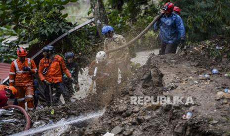 Petugas gabungan menyemprotkan air untuk mencari korban yang tertimbun tanah longsor di Kampung Sirnasari, Kelurahan Empang, Kecamatan Bogor Selatan, Kota Bogor, Jawa Barat, Rabu (15/3/2023). 