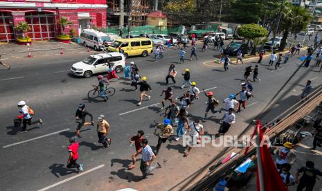  Pengunjuk rasa pro-demokrasi mencalonkan diri sebagai polisi anti huru hara maju ke arah mereka selama unjuk rasa menentang kudeta militer di Yangon, Myanmar, 27 Februari 2021.