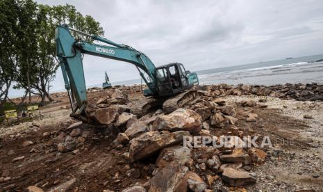 Pekerja menggunakan alat berat menyelesaikan pembangunan pemecah gelombang di Kawasan Ekonomi Khusus (KEK) Tanjung Lesung, Pandeglang, Banten, Ahad (13/2/2022). Pemerintah melalui Kementerian PUPR, membangun pemecah gelombang sepanjang 14,5 Km guna mengantisipasi abrasi di kawasan KEK Tanjung Lesung. 