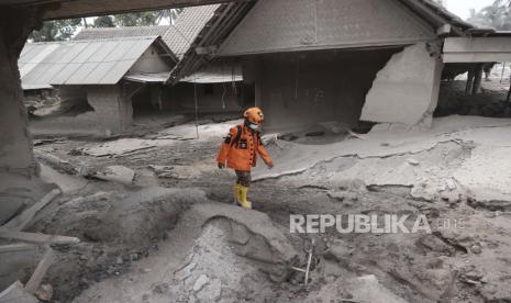 Seorang penyelamat berjalan di daerah yang dilanda letusan Gunung Semeru di Kabupaten Lumajang, Provinsi Jawa Timur, Indonesia, 5 Desember 2021.