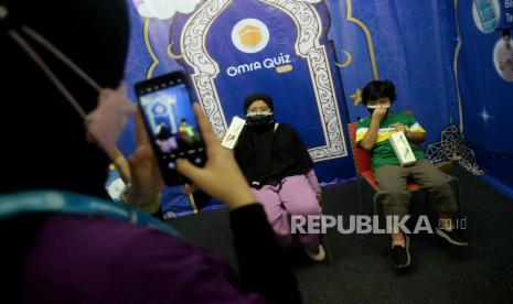 Karyawan memfoto anak-anak yang sudah bermain dengan aplikasi game Omra Quiz Live di Muslim Life Fair 2022, Istora Senayan, Jakarta, Sabtu (26/3/2022). Omra Quiz Live merupakan game edukatif yang mengajak pemain untuk menjawab pertanyaan-pertanyaan yang bersifat religi islam dengan tujuan para pemain bisa belajar Islam sambil bersenang-senang. 