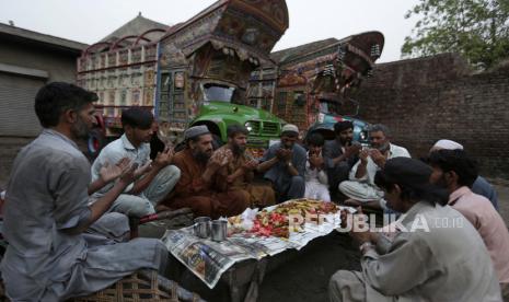 Sopir truk berdoa sebelum berbuka puasa selama bulan puasa Ramadhan di terminal, di Lahore, Pakistan, Selasa, 12 April 2022. Ramadhan ditandai dengan puasa setiap hari dari fajar hingga matahari terbenam.