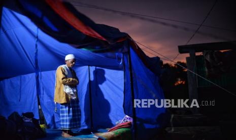 Pengungsi melaksanakan shalat di dalam tenda darurat di Kampung Gitung, Desa Mangunkerta, Kecamatan Cugenang, Kabupaten Cianjur, Jawa Barat, Ahad (27/11/2022). Beberapa pengungsi korban gempa Cianjur mengisi waktu malam hari di tenda pengungsian dengan menggelar tahlil atau menyaksikan pertandingan piala dunia. Republika/Thoudy Badai