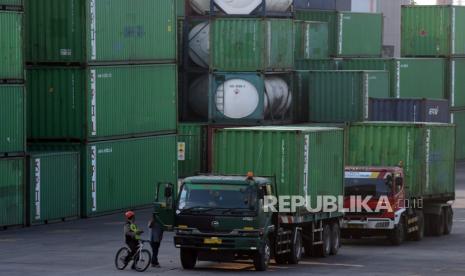 Petugas keamanan berbicara dengan sopir saat memantau aktivitas bongkar muat peti kemas di Pelabuhan Tanjung Priok, Jakarta, Senin (17/7/2023).