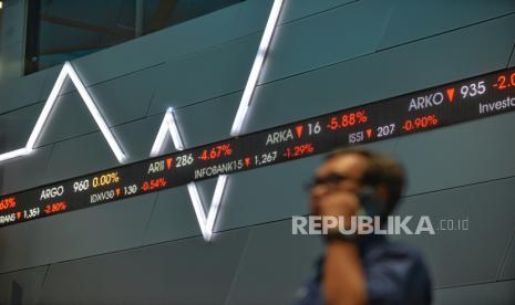 Karyawan beraktivitas di dekat layar elektronik yang menampilkan pergerakan Indeks Harga Saham Gabungan (IHSG).