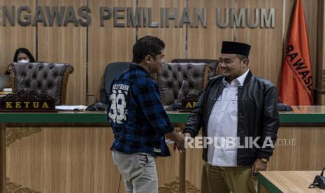 Komisioner KPU Mochammad Afifuddin (kanan) selaku perwakilan pihak terlapor berjabat tangan dengan Sekjen Prima Dominggus Oktavianus (kiri) selaku perwakilan pihak pelapor usai mengikuti Sidang Putusan Penanganan Dugaan Pelanggaran Adminstrasi Pemilu 2024 di Kantor Bawaslu, Jakarta, Senin (20/3/2023). Majelis Sidang Bawaslu memutuskan bahwa pihak terlapor yakni Komisi Pemilihan Umum (KPU) terbukti melakukan pelanggaran administratif pemilu dan memerintahkan KPU melakukan proses verifikasi administrasi syarat perbaikan dari Partai Rakyat Adil Makmur (Prima) dalam waktu 10 x 24 jam melalui Sipol. ANTARA FOTO/Aprillio Akbar/nym.