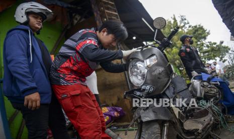 Warga melihati motor yang hancur akibat ditabrak truk. (Ilustrasi)